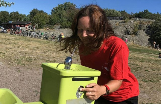 Kvinna dricker ur en fontän.