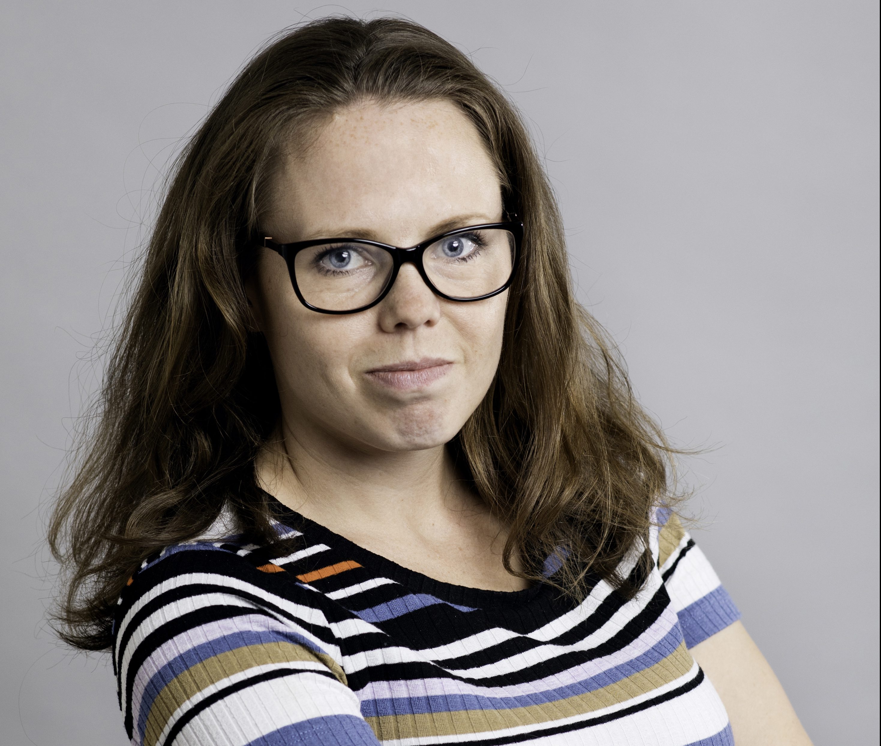 Bild på Alexandra Mattson, halvkropp i randig tröja mot vit bakgrund. Foto Jessica Segerberg