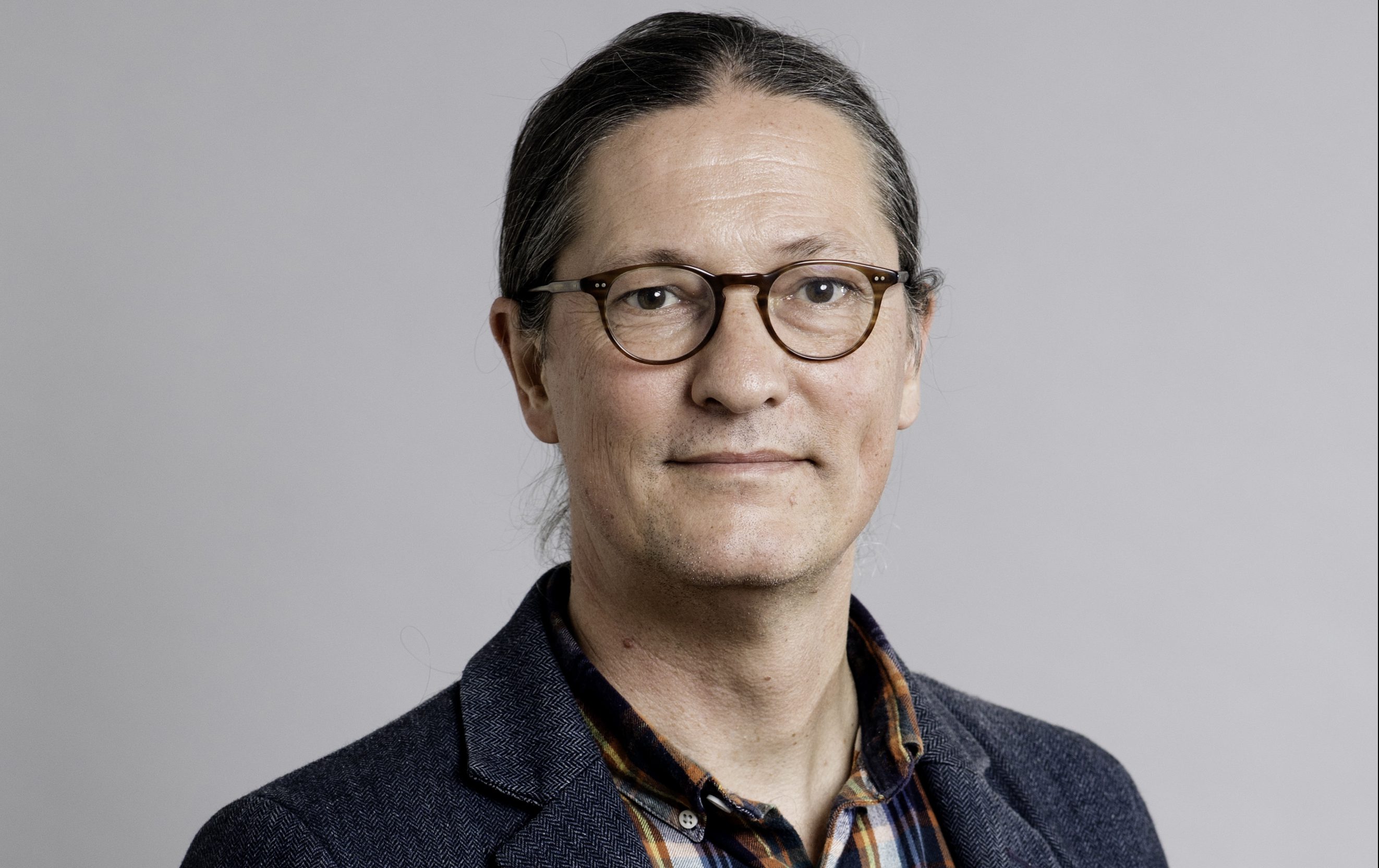 Rikard Warlenius foto Jessica Segerberg. Rikard halvkropp mot grå bakgrund.