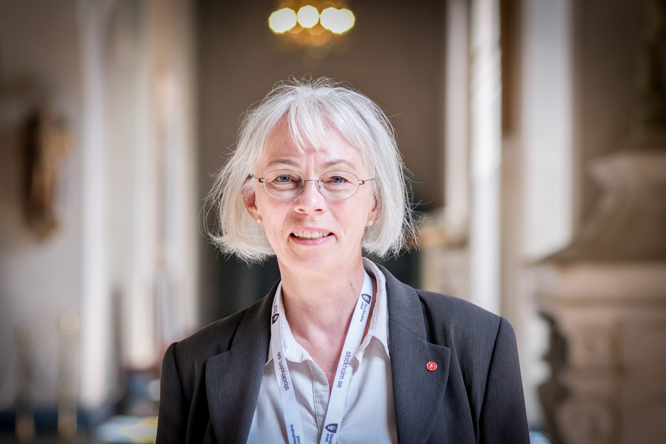 Porträtt av Torun Boucher tagen inomhus i stadshuset. Torun har en kavaj och vit skjorta på sig.
