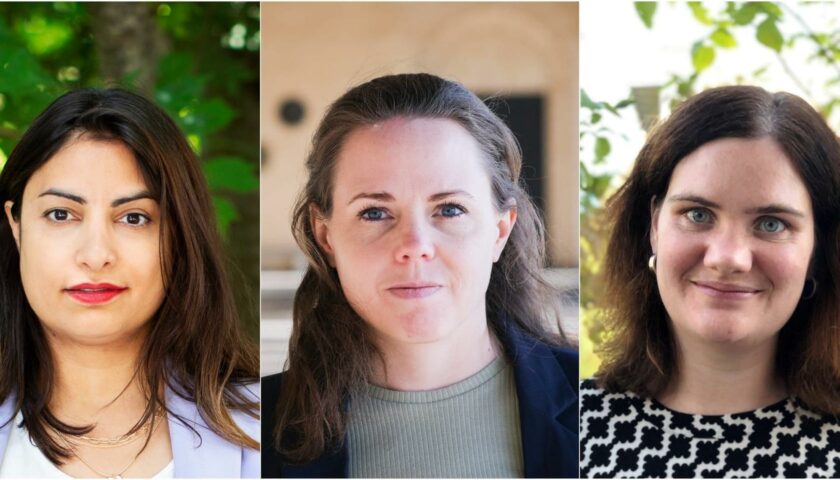 Porträtt på tre kvinnor utomhus. Från vänster: Nooshi Dadgostar med mörkt hår och röd läppfärg, Alexandra Mattsson med löst hår, samt Anna-Klara Behlin med axellångt mörkt hår och ett svartvitt mönstrat plagg. Bakgrunden varierar mellan grönska och ljus byggnad.